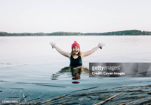 nordic woman enjoying cold water swimming in sweden - woman ice stock-fotos und bilder