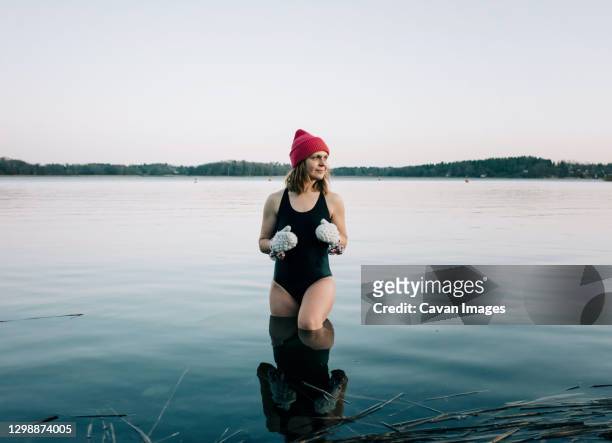nordic woman stood on the baltic sea ready for cold water swimming - freeze motion stock-fotos und bilder