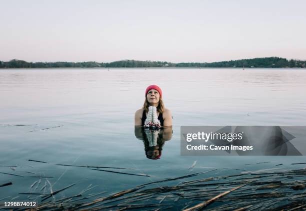 nordic woman focusing on breathing whilst swimming in the baltic sea - eis baden stock-fotos und bilder