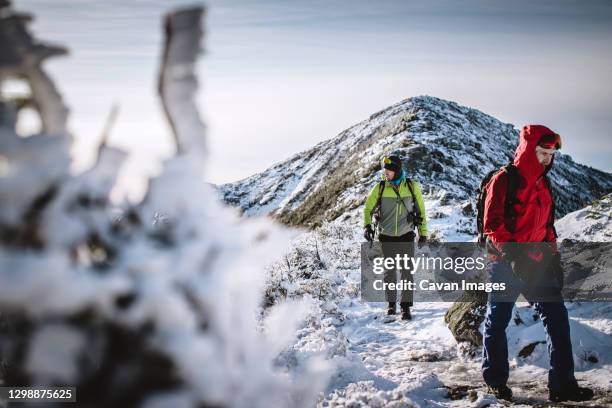 two winter hikers on snowy frozen trail in mountains of new hampshire - hiking appalachian trail stock pictures, royalty-free photos & images