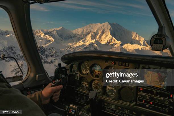 man flies a small airplane at sunset with alpenglow on mount foraker - alaska mountain range stock pictures, royalty-free photos & images