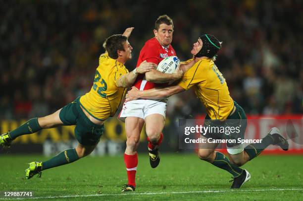 Shane Williams of Wales is tackled by Rob Horne and Berrick Barnes of the Wallabies during the 2011 IRB Rugby World Cup bronze final match between...