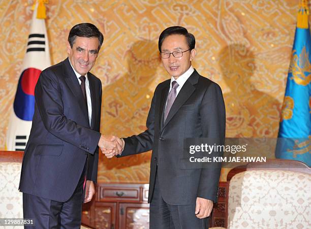 French Prime Minister Francois Fillon shakes hand with South Korean President Lee Myung-Bak at the president's office in Seoul on October 21, 2011....