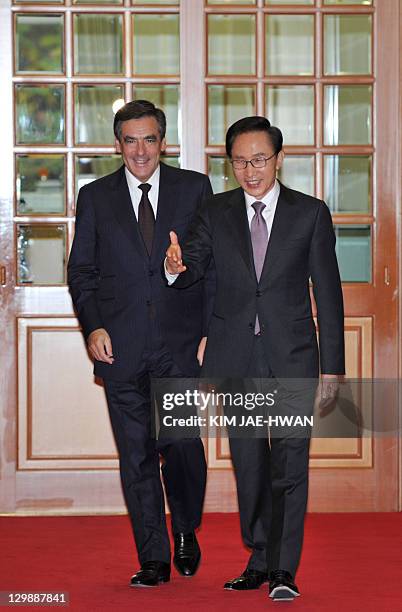 French Prime Minister Francois Fillon and South Korean President Lee Myung-Bak walk together into the president's office in Seoul on October 21,...