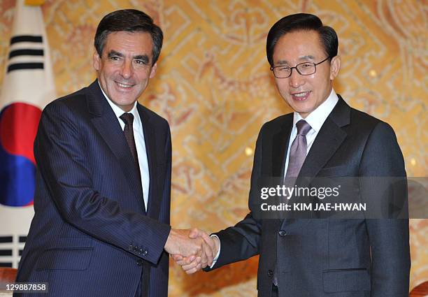 French Prime Minister Francois Fillon shakes hand with South Korean President Lee Myung-Bak at the president's office in Seoul on October 21, 2011....