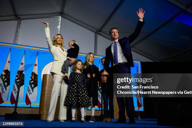 Governor Gavin Newsom, his wife Jennifer Siebel Newsom and his children wave to the crowd after taking the oath of office during his inauguration...