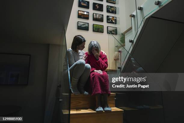 woman comforting her upset elderly mother - mother upset stock-fotos und bilder