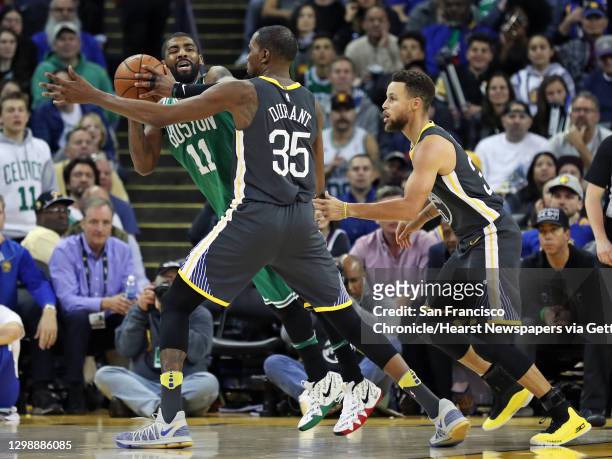 Golden State Warriors' Kevin Durant and Stephen Curry guard Boston Celtics' Kyrie Irving in 4th quarter during Warriors' 109-105 win in NBA game at...