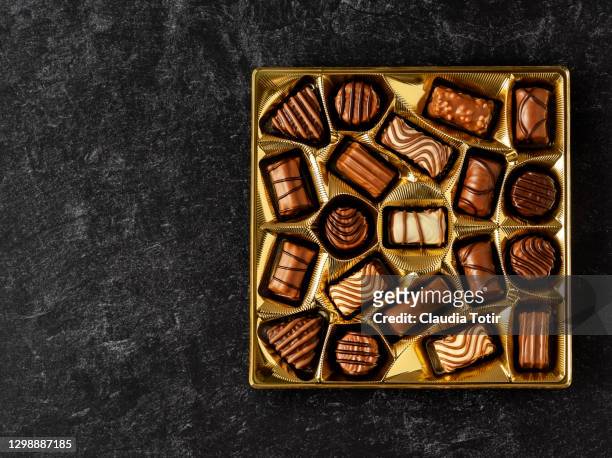box of chocolates on black background - box of chocolate stockfoto's en -beelden