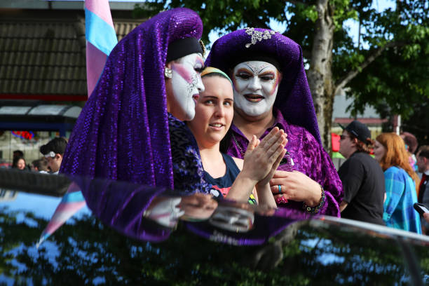 Woman stands with the Sisters of Perpetual Indulgence during the TransPride march and rally at Cal Anderson Park, Friday, June 28, 2019.