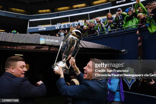 Macklemore, a part-owner of the Sounders, holds up the trophy after Seattle won the MLS Cup final 3-1 against Toronto FC, Sunday, Nov. 10, 2019.