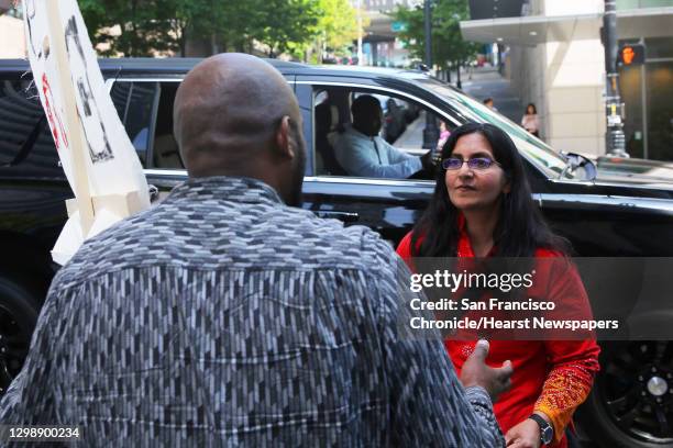 Seattle city councilmember Kshama Sawant speaks with Fasil Teka as Uber and Lyft drivers gathered outside City Hall, Thursday, to protest what they...