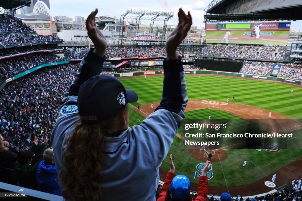Fans cheer as Mariner's Tim Beckham crosses home plate after hitting the first of his two homeruns and five team homeruns during the Seattle's home-opener against the Boston Red Sox at the newly renamed T-Mobile Park, Thursday, March, 28, 2019. (Genna Ma