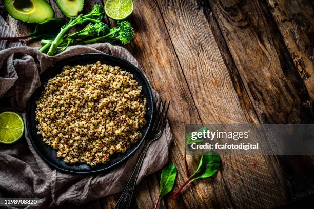 gekochte quinoa-platte auf rustikalem holztisch. kopierraum - amarant stock-fotos und bilder