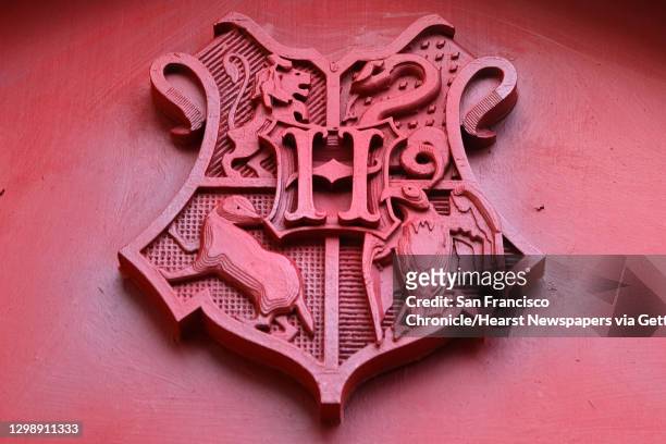 Printed Hogwarts crest is fixed to a store front as the finishing touches are put on a re-creation of Diagon Alley, a shopping street location from...