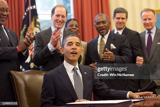 President Barack Obama receives applause after signing the Colombian free trade agreement in the Oval Office of the White House in October 21, 2011...