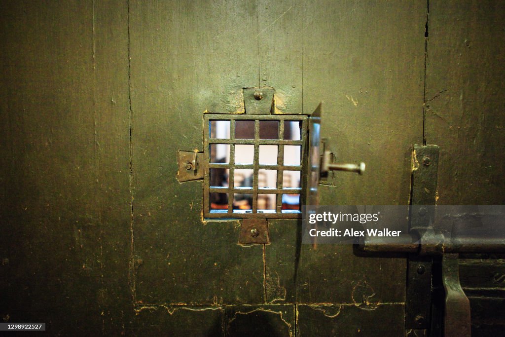 Old wooden prison door window grid.