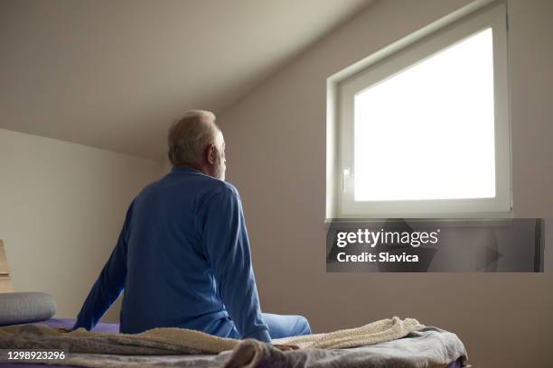 hombre mayor en pijama despertando - viudo fotografías e imágenes de stock