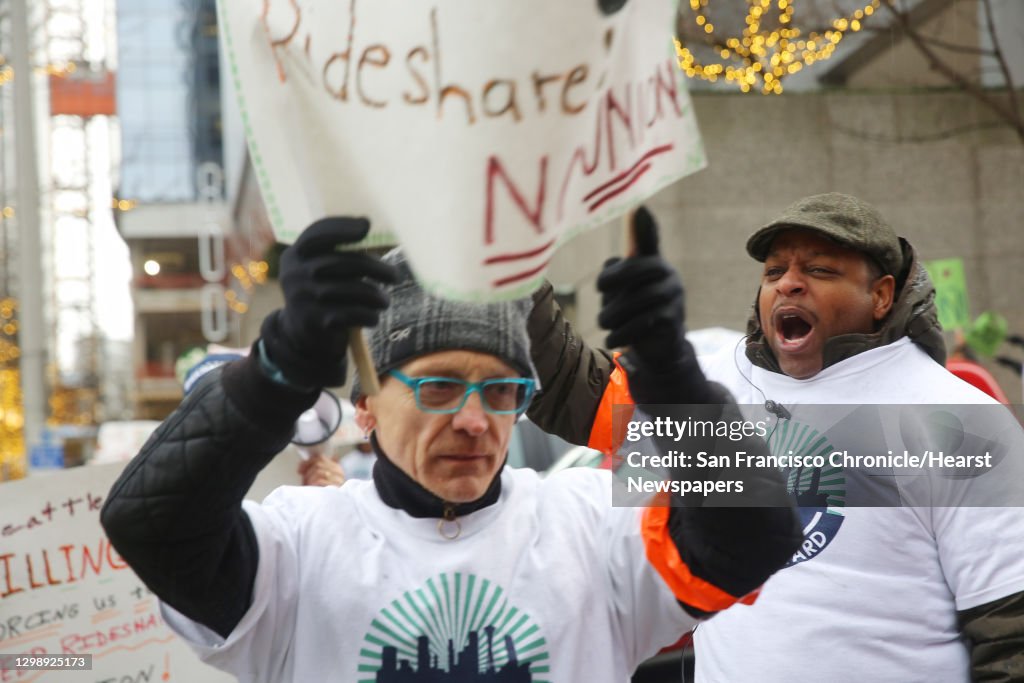 Charles Jenkins, right, and other Uber and Lyft drivers protest outside of the Seattle Municipal Tower, Tuesday, as the city's law allowing drivers to decide if they want to bargain collectively goes into effect today. (Genna Martin, seattlepi.com)