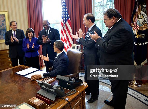 President Barack Obama, seated, gestures after signing the Korea, Panama, Colombia Free Trade Agreements and the renewal of Trade Adjustment...