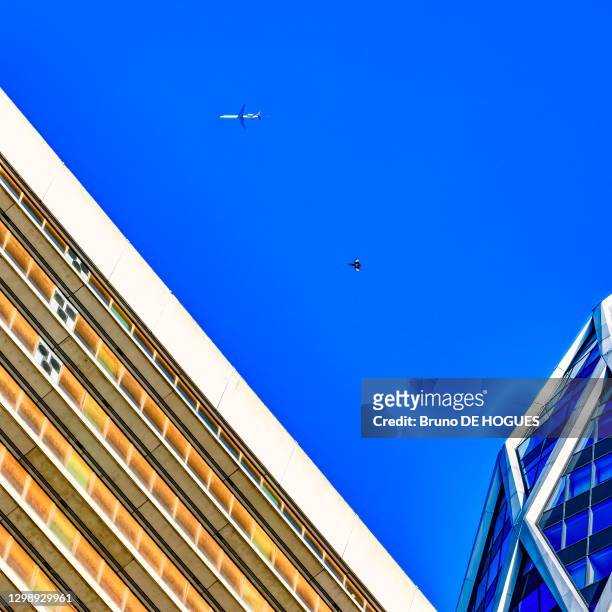 Un avion et une pie dans le ciel bleu de La Défense, 15 Octobre 2017, Courbevoie, France.