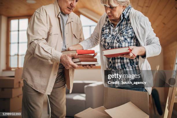 senior couple unpacking in their new home - disorganize stock pictures, royalty-free photos & images