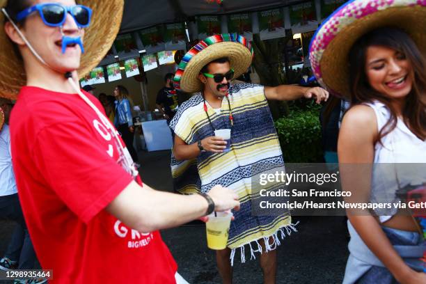 Rich Goodloe, left, Kenzo Kressbach, center, and Samantha Lee dance at the annual Cinco de Mayo block party hosted by the Green Lake Tacos Guaymas,...