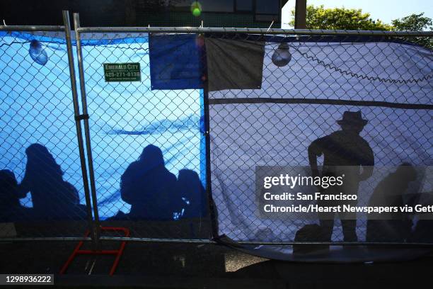 Party goers are silhouetted inside the fence at the annual Cinco de Mayo block party hosted by the Green Lake Tacos Guaymas, March 5, 2016. The party...