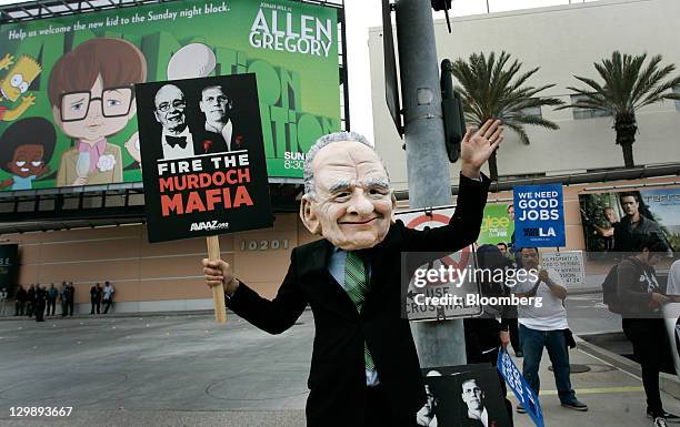 Demonstrator wearing a Rupert Murdoch mask protests outside of Fox Studios during News Corp.'s annual shareholders meeting in Los Angeles,...