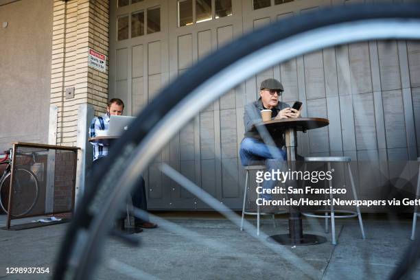 Lukas Bruggemann and Danon Hyldreth engage in their electronics whlie having coffee outside Blue Bottle Coffee in Oakland, California, on Tuesday,...