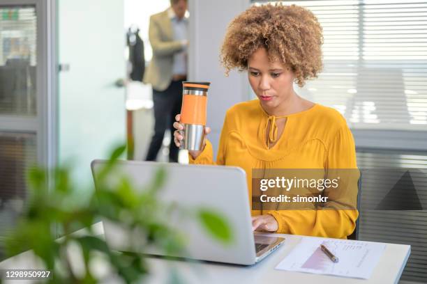 businesswoman using laptop in office - reusable water bottle office stock pictures, royalty-free photos & images