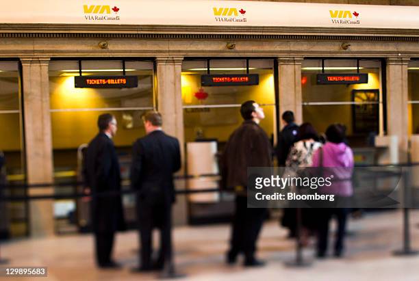 Passengers wait in line at a Via Rail Canada Inc. Ticket booth in this photo taken with a tilt-shift lens in Toronto, Ontario, Canada, on Tuesday,...