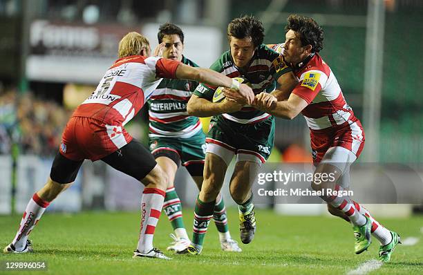 Matt Smith of Tigers is tackled by Tom Voyce and Jim Hamilton of Gloucester during the LV Cup match between Leicester Tigers and Gloucester at...