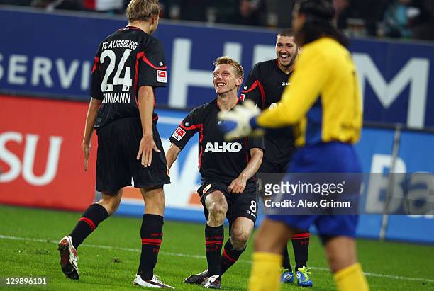 Axel Bellinghausen of Augsburg celebrates his team's first goal with team mates Daniel Brinkmann and Sascha Moelders during the Bundesliga match...