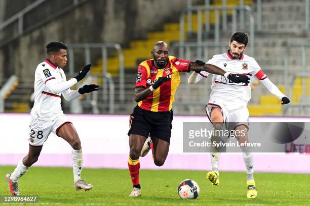Seko Fofana of RC Lens is challenged by Hicham Boudaoui of OGC Nice and Pierre Lees Melou of OGC Nice during the Ligue 1 match between RC Lens and...