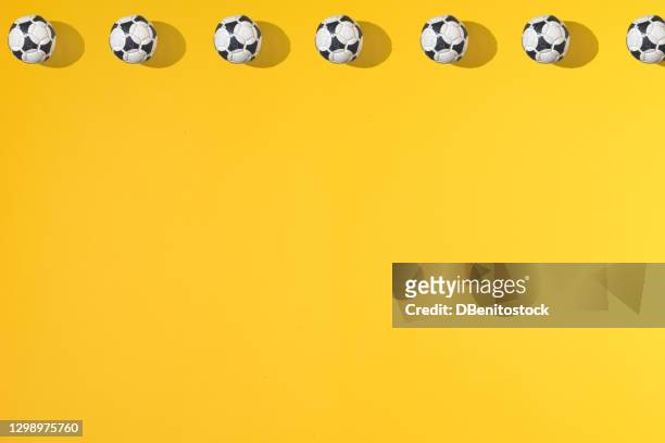 a top line of old soccer balls on a yellow background. - football player icon stock pictures, royalty-free photos & images