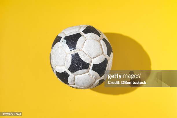 an old and worn soccer ball on a yellow background. - scoring soccer stock pictures, royalty-free photos & images