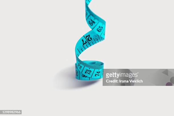 tape measure in blue color on light gray background. - measure length stock pictures, royalty-free photos & images