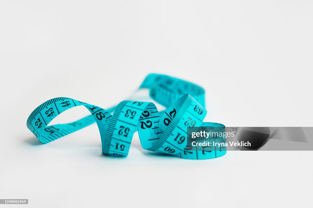 Tape Measure in blue color on light gray background.