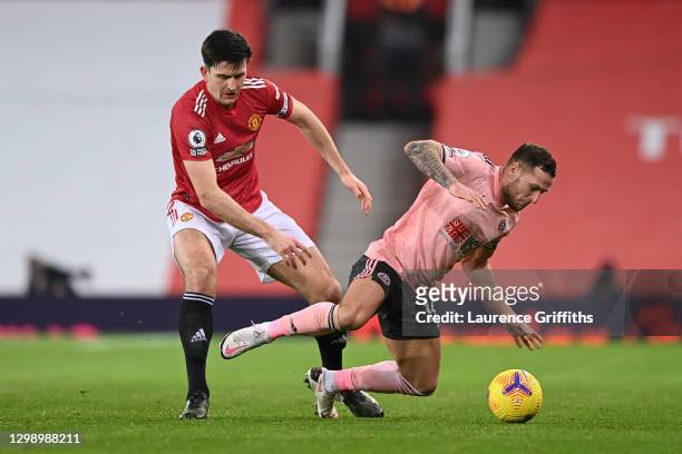 Harry Maguire of Manchester United tackles Billy Sharp of Sheffield United during the Premier League match between Manchester United and Sheffield...