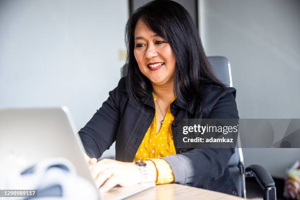 mature asian woman working - filipino ethnicity stock pictures, royalty-free photos & images