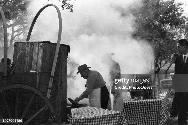 View of cooks as they prepare a barbecue meal at President Lyndon Johnson's ranch, Johnson City, Texas, December 1963. Visible at right are members...