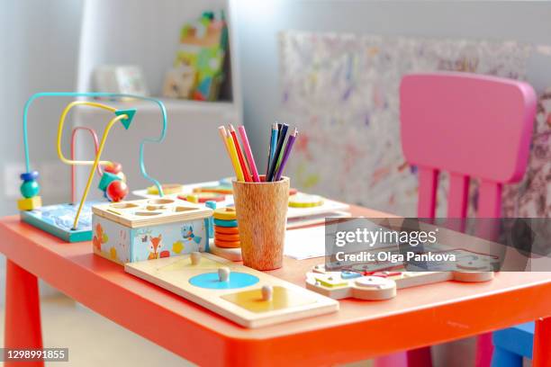 children's table in orange color with various educational materials. children's individual workplace for preschoolers and elementary school students. - preschool art stock pictures, royalty-free photos & images