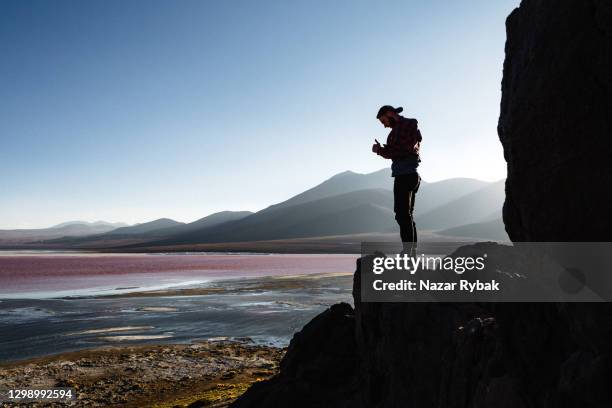 kaukasischer mann steht und schaut auf die malerische aussicht auf laguna colorada in altiplano, bolivien - bolivia stock-fotos und bilder