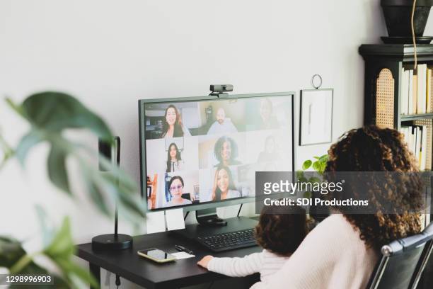 junge mutter nimmt an videokonferenz teil, während sie sich um sohn kümmert - baby monitor stock-fotos und bilder