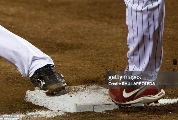 Mexican Agustin Murillo tries to put out on third base Dominican Dionys Cesar during their match in the XVI Panamerican Games in Lagos de Moreno,...