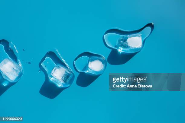 cubes of melting ice on blue background with drops - ice cubes background ストックフォトと画像