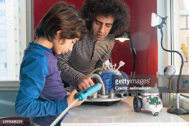 padre e hijo diseñando una nave espacial de ciencia ficción - desk lamp fotografías e imágenes de stock