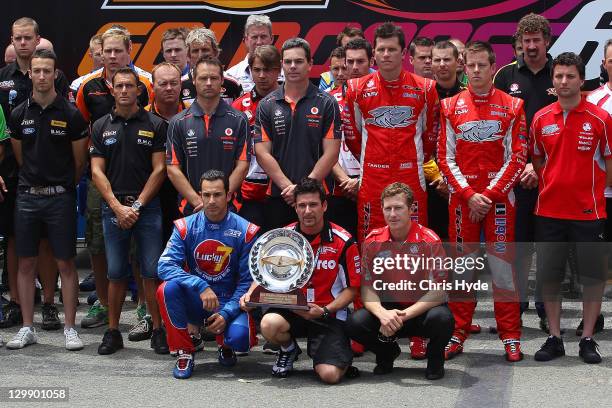 IndyCar drivers Helio Castroneves, Alex Tagliani and Ryan Briscoe hold the Dan Wheldon Memorial Trophy during a tribute to the driver during the V8...