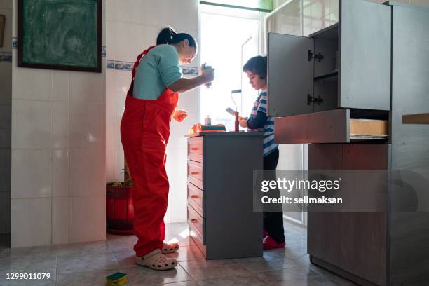 photo of mother ans son painting kitchen cabinet at home - 40 44 ans stock pictures, royalty-free photos & images